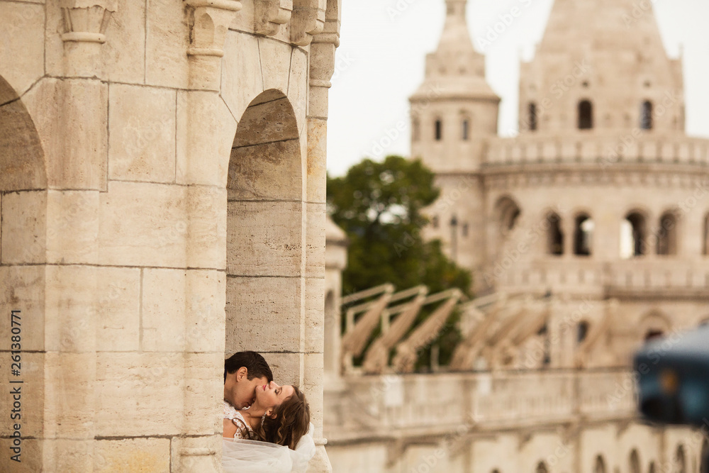 Young beautiful stylish pair of newlyweds kissing by the Fisherman's Bastion in Budapest, Hungary