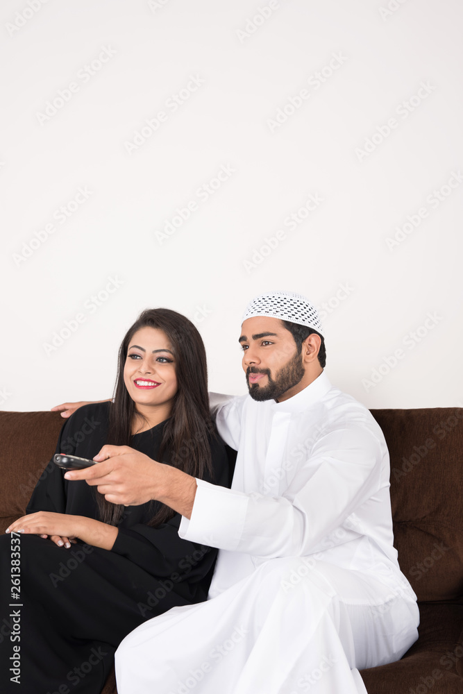 Arab couple watching TV at home