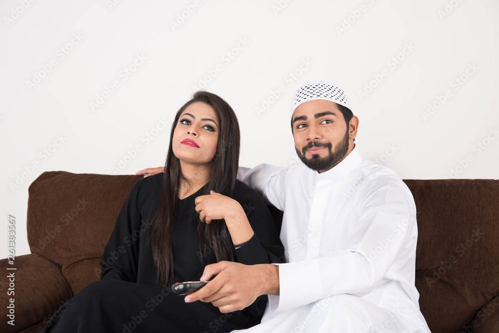 Arab couple watching TV at home