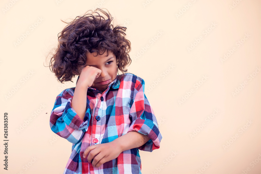 Sad kid with curly hair over isolated background Sad kid with curly hair over isolated background