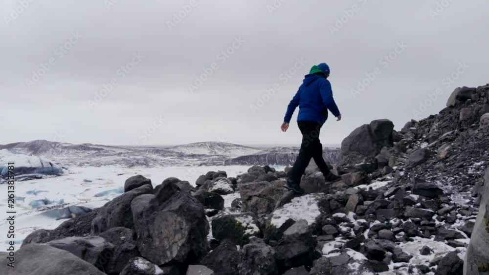 A man running and parkour jumps a mountain road with snow covered mountains in the background. A man running and parkour jumps a mountain road with snow covered mountains in the background.