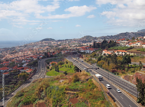 an aerial cityscape view of funchal showing traffic on the main VR1 motorway running into the city with the coast visible in the distance © Philip J Openshaw 