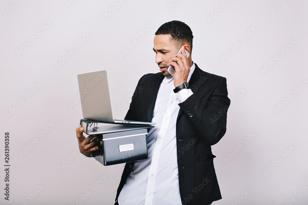 Hard-working astonished businessman with office box, folders, laptop talking on phone on white background. Office worker, career, smart manager, misunderstanding, leadership Hard-working astonished businessman with office box, folders, laptop talking on phone on white background. Office worker, career, smart manager, misunderstanding, leadership