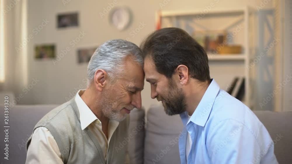 Middle-aged and senior males touching foreheads good relations between relatives Middle-aged and senior males touching foreheads good relations between relatives