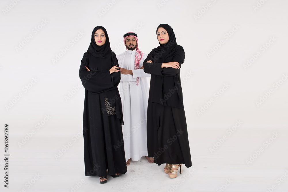 Two arab females with one male smiling and standing on white background