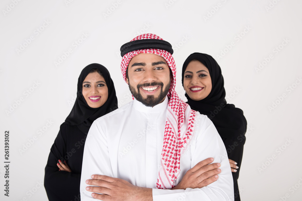 Two arab females with one male smiling and standing on white background