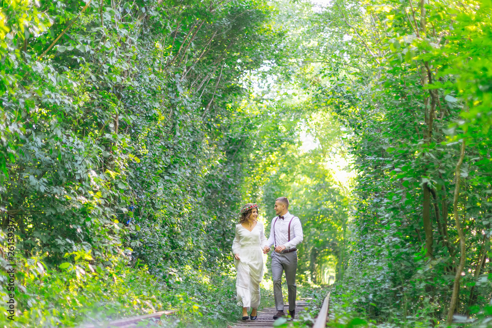 the couple in love hold hands and run along the railroad. tree t