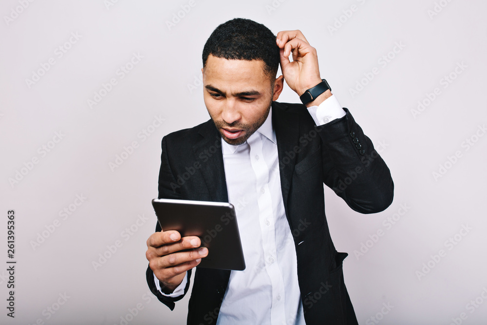 Portrait young handsome man in white shirt and black jacket at work with tablet on white background. Fashionable businessman, misunderstanding, busy, successful, modern lifestyle Portrait young handsome man in white shirt and black jacket at work with tablet on white background. Fashionable businessman, misunderstanding, busy, successful, modern lifestyle