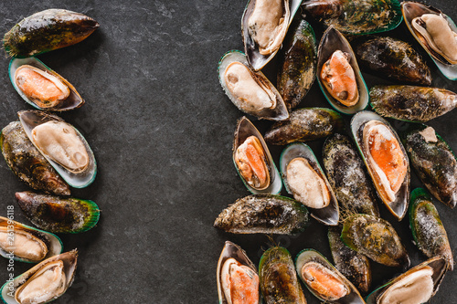 Raw kiwi mussels on slate stone background. Seafood, Shellfish, top view, flat lay, copy space