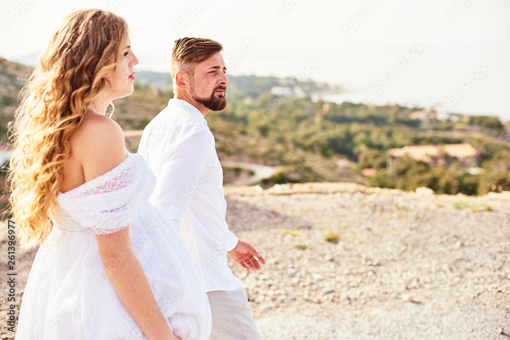 Young pregnant woman walking with her husband on a sunny day