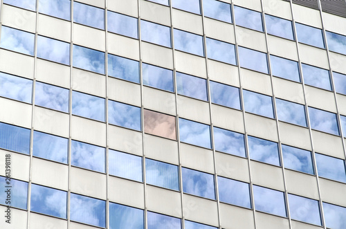 cloudy sky reflecting in windows of office building