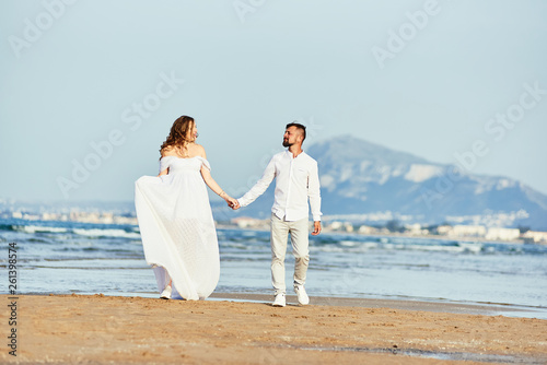 Young pregnant woman walking with her husband on the beach © bodiaphoto