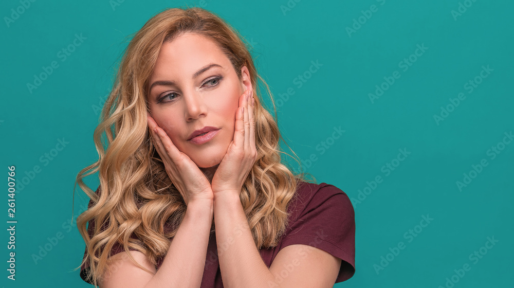 Fototapeta premium Young attractive blonde on a blue background.