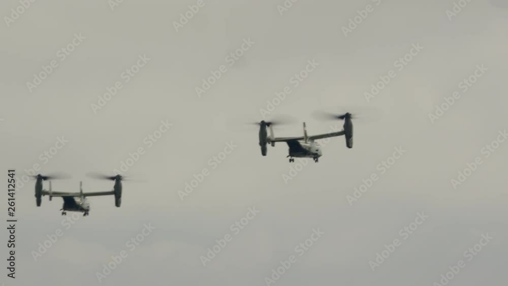 Several bell Boeing V-22 Osprey helicopters fly over the beautiful ocean coast. A powerboat is sailing along the coast. Summer, daytime, wide shot, pan. 4K/ 10bit/ ProRes 422HQ/ BT.2020 Several bell Boeing V-22 Osprey helicopters fly over the beautiful ocean coast. A powerboat is sailing along the coast. Summer, daytime, wide shot, pan. 4K/ 10bit/ ProRes 422HQ/ BT.2020