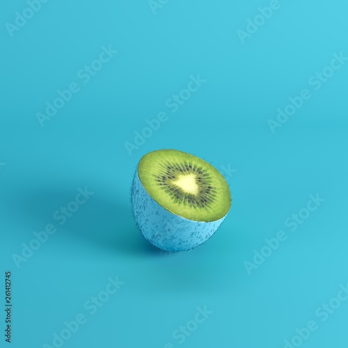 Half of ripe green kiwi fruit with peel painted in blue isolated on blue background. Minimal fruit idea concept.