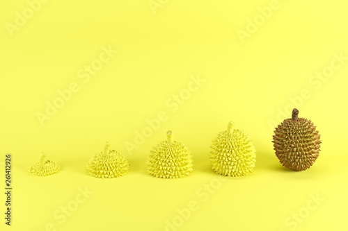 Outstanding whole ripe durian and slices of durian painted in yellow on yellow background. Minimal fruit idea concept.