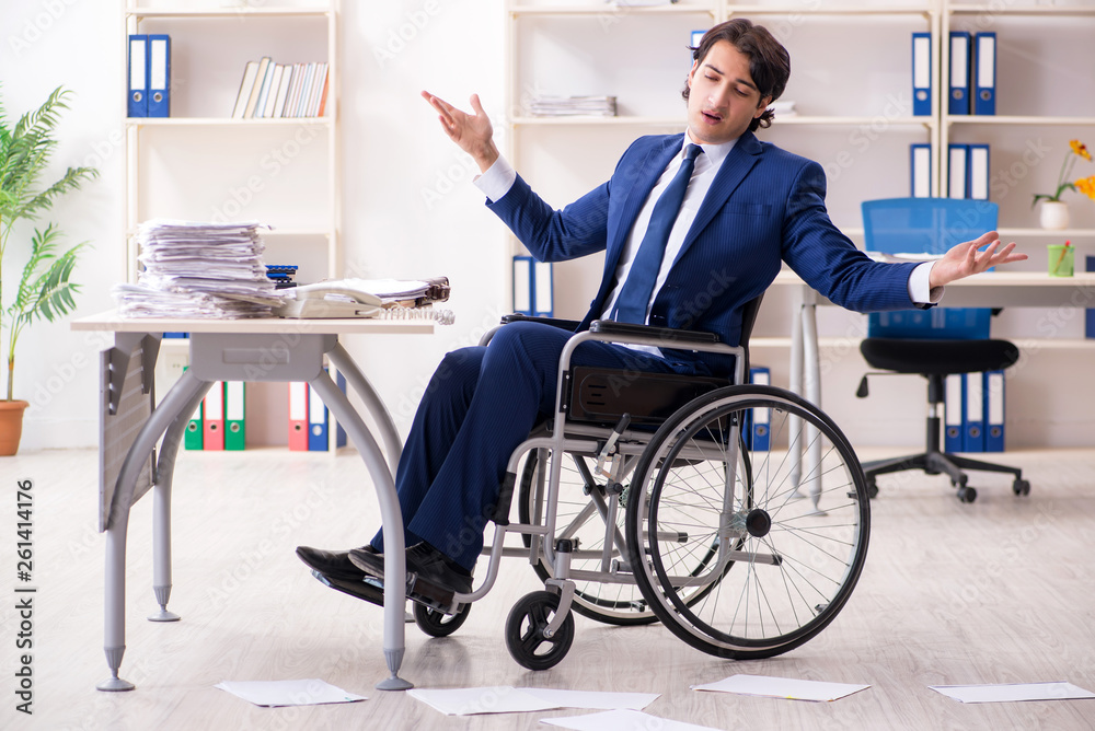 Young male employee in wheelchair working in the office Young male employee in wheelchair working in the office