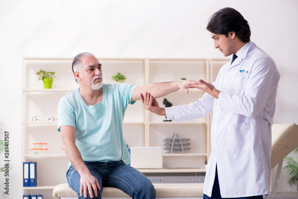 Old man visiting young male doctor Old man visiting young male doctor