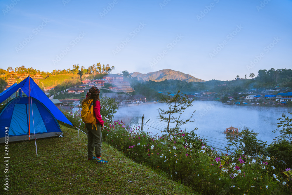 The girl set up a camp on the mountain near the lake, Camping Travel Concept, natural rhythms, fog in the winter.