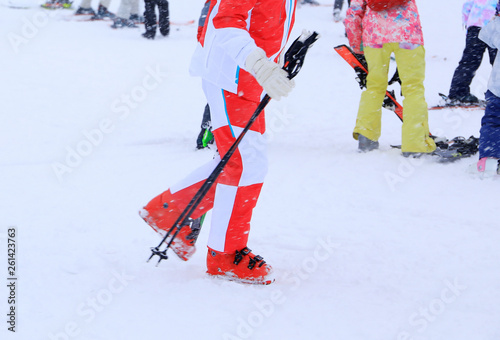 Skiers in red dress walking slowly at the ski area