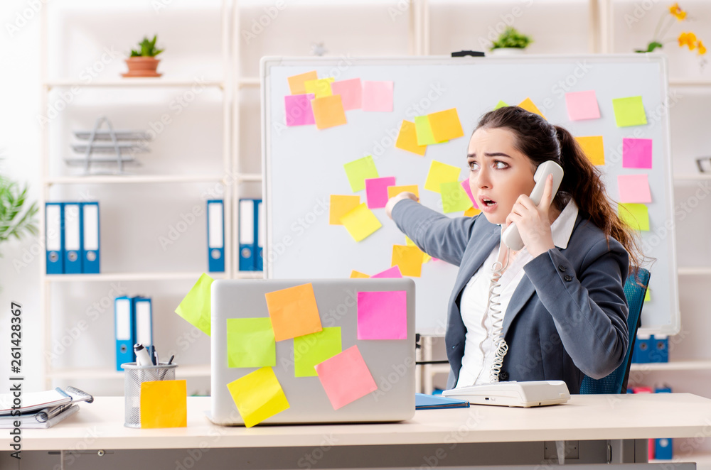 Young female employee in conflicting priorities concept 