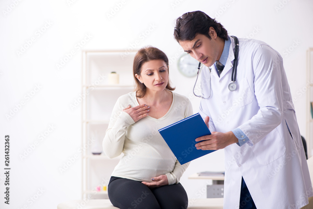 Old pregnant woman visiting young male doctor 