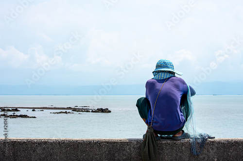 Man holding fishing nets Background sea and sky.