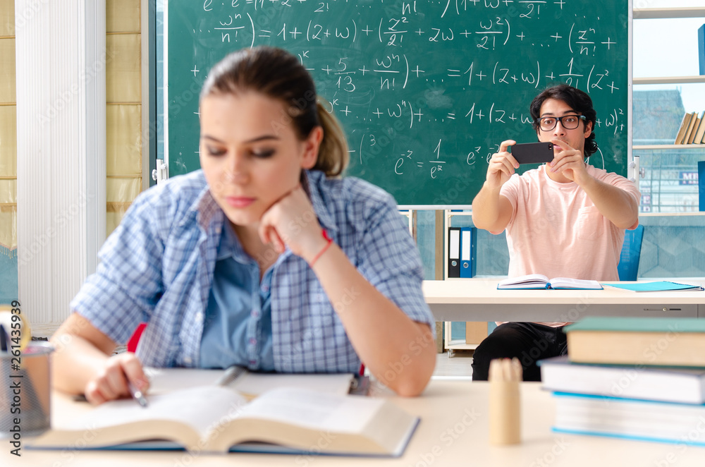 Young students taking the math exam in classroom Young students taking the math exam in classroom