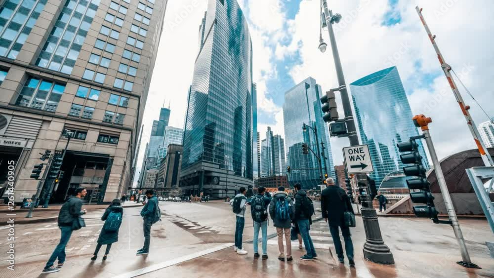 4K UHD time-lapse of road intersection in business district Chicago, USA. People walking and car traffic transport across streets. American city life concept