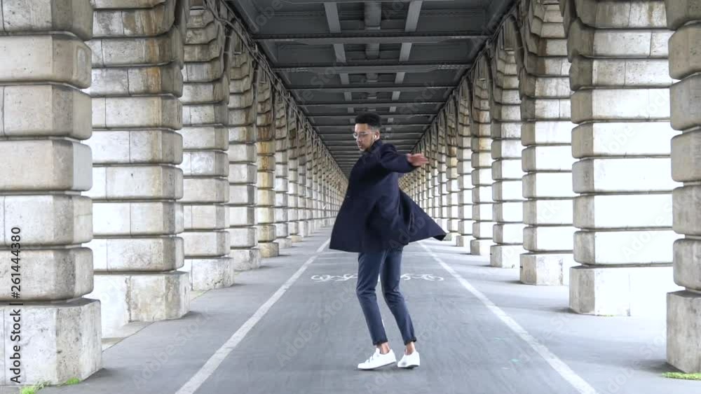 Slow motion of businessman dancing under Pont de Bercy bridge