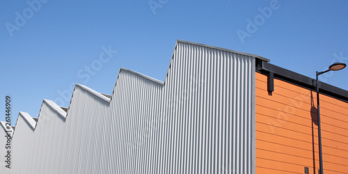 industrial building type gray and orange factory in the blue sky