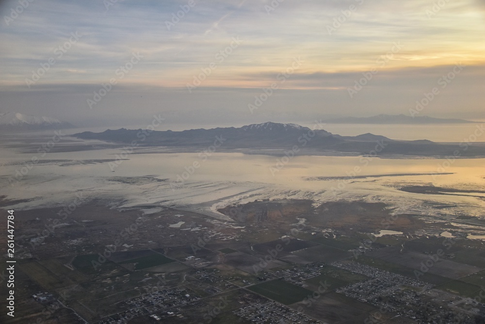 Aerial view from airplane of Antelope Island at sunset, view from Magna, sweeping cloudscape at sunrise with the Great Salt Lake State Park in winter. USA, Utah. Aerial view from airplane of Antelope Island at sunset, view from Magna, sweeping cloudscape at sunrise with the Great Salt Lake State Park in winter. USA, Utah.