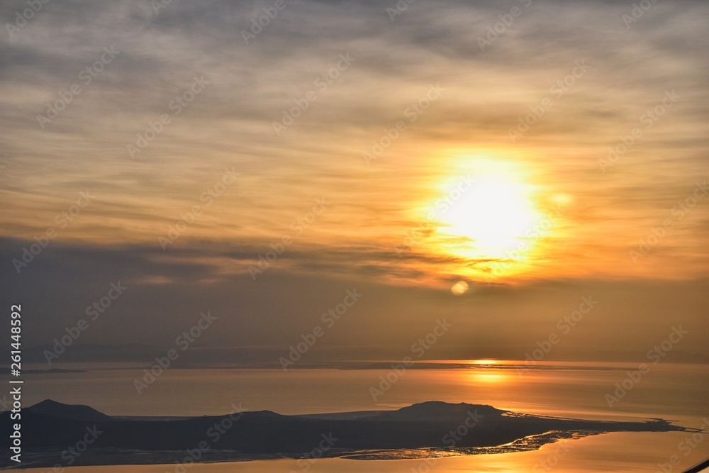 Aerial view from airplane of Antelope Island at sunset, view from Magna, sweeping cloudscape at sunrise with the Great Salt Lake State Park in winter. USA, Utah. Aerial view from airplane of Antelope Island at sunset, view from Magna, sweeping cloudscape at sunrise with the Great Salt Lake State Park in winter. USA, Utah.