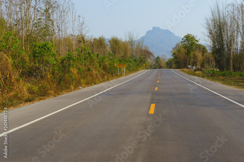 country road leading towards mountain in Thailand