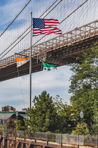 US flag flying against Brooklyn Bridge, in Brooklyn Bridge Park, New York, USA © Mark Zhu