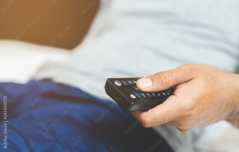 Hand man holding television remote.