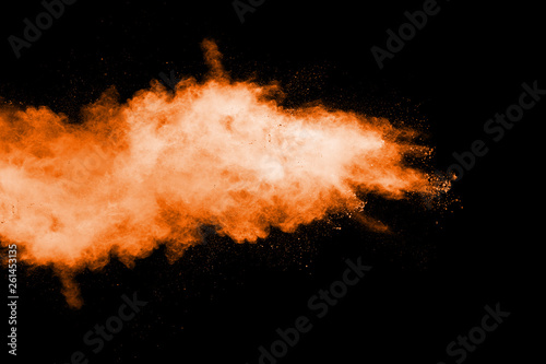 Orange color powder explosion on black background.