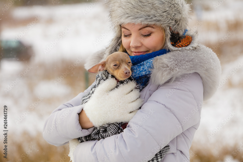 Woman hug warming her little dog in winter Woman hug warming her little dog in winter