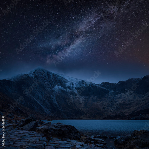Composite image of Winter landscape of snowcapped Mountain Range at night with Milky Way above © veneratio