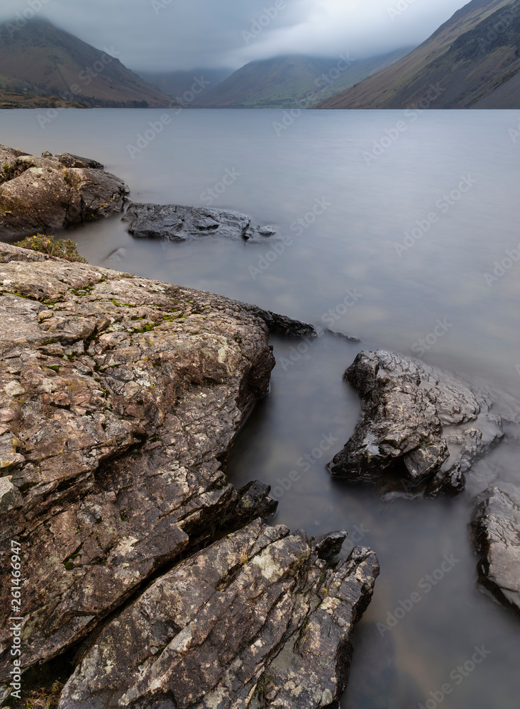 Stunning long exposure landscape image of Wast Water in UK Lake District during moody Spring evening