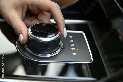 the joystick gear shift of the automatic transmission. women's hand includes a drive mode on the automatic transmission close-up