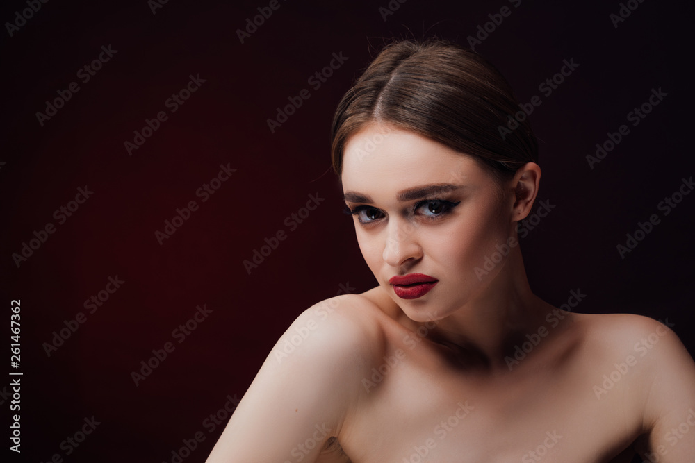 Woman blowing smoke against black background. Studio fashion photo. 