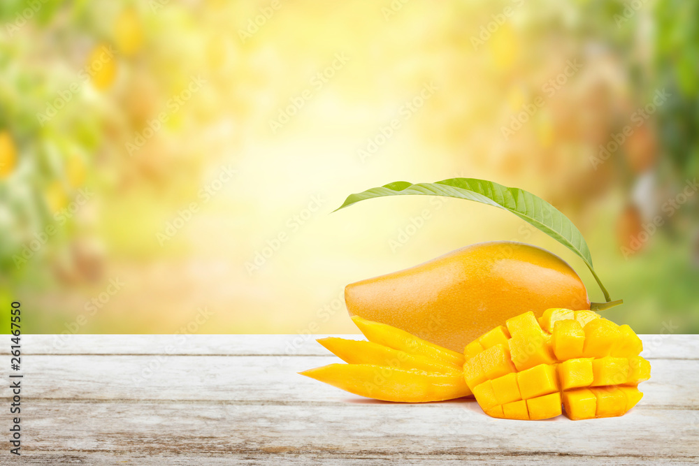 Mango Fruit Slice And Half Cut With Green Leaf Put On Old Wood Table