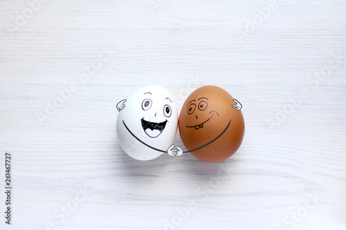 white and colored eggs fun hugging each other. International Friendship Day photo