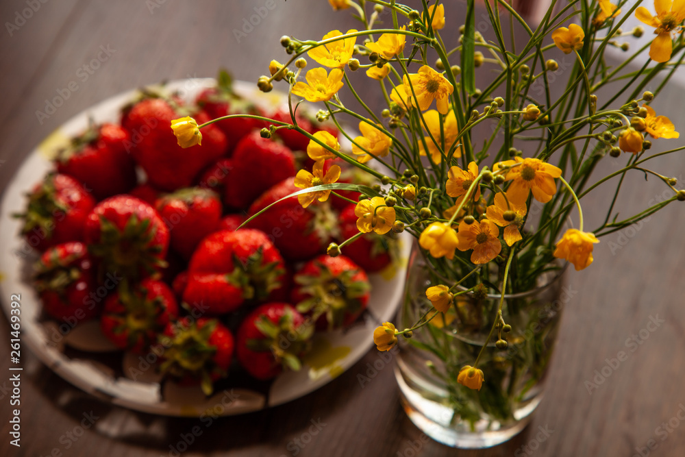 Strawberry and yellow buttercup flowers nature morte