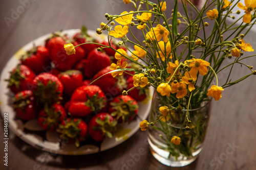 Strawberry and yellow buttercup flowers nature morte
