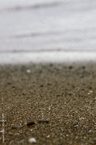 Texture of yellow sea sand and sea water, horizon between sea and coast, blurred background
