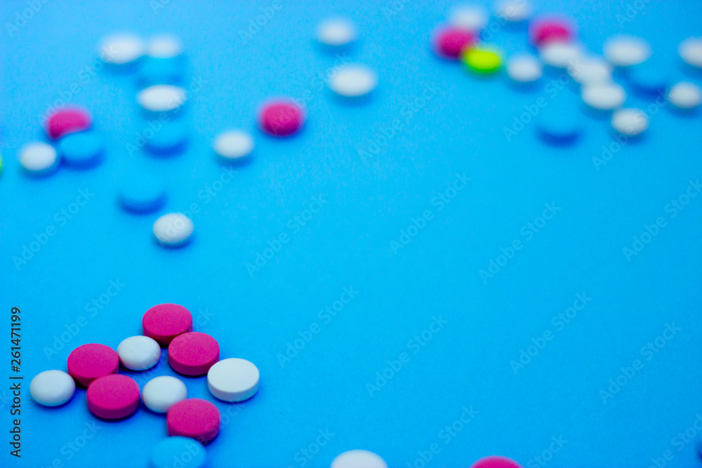 Multi-colored pills on a blue background Multi-colored pills on a blue background