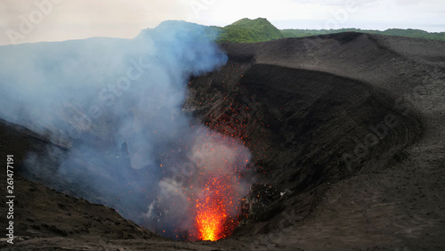 Stunning shot of an active volcano spewing out glowing lava high in the air.