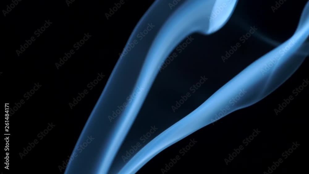 Thin trickle of blue smoke slowly rising graceful twists up on black background. Smoke billow rising swirl to top on black background. Closeup Thin trickle of blue smoke slowly rising graceful twists up on black background. Smoke billow rising swirl to top on black background. Closeup